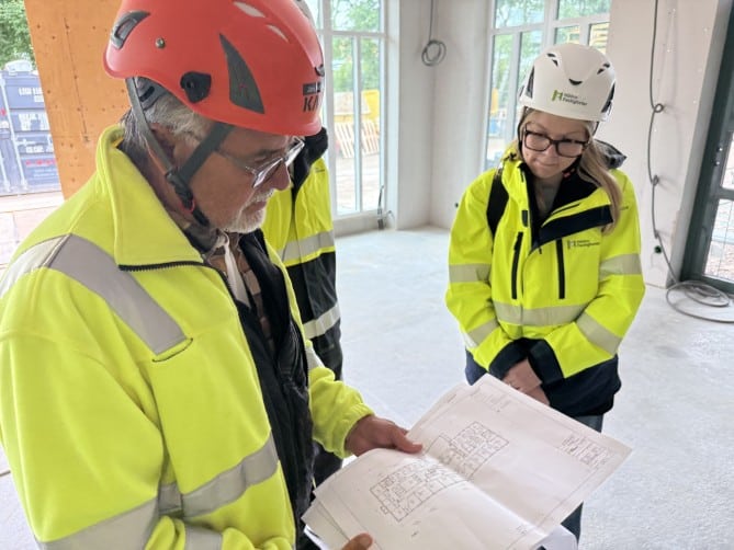 Två personer tittar på en planritning
