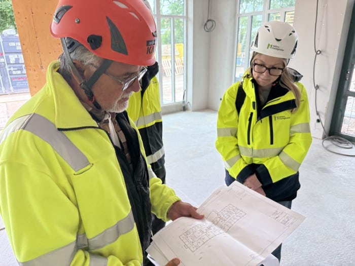 Två personer tittar på en planritning